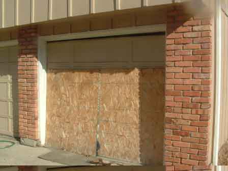 Damaged And Boarded Garage Door